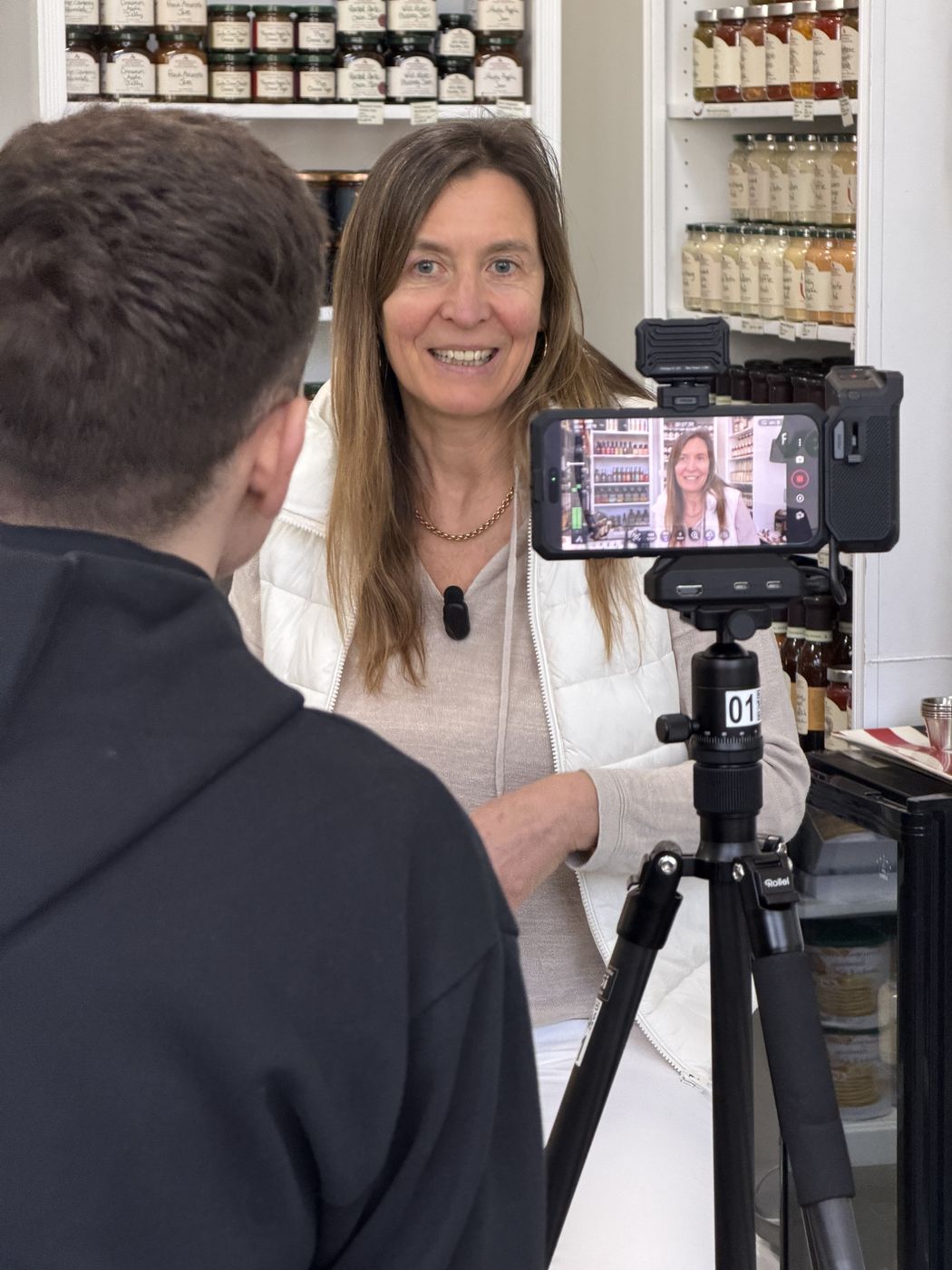 Sabine Ryan wird in ihrem Laden vor Regalen mit Gläsern für ein Video gefilmt